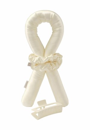 Soft cream-colored fabric hair curler with scrunchie and matching wide-tooth plastic hair clip on white background.