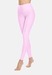 Růžové legíny s vysokým pasem vyrobené z elastické tkaniny, s hladkým povrchem a prodlouženým designem nohavic, vhodné pro aktivní nošení.