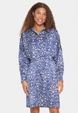 Abito blu con motivo, caratterizzato da un colletto, maniche lunghe e una vestibilità comoda. Il design include motivi floreali bianchi e paisley.
