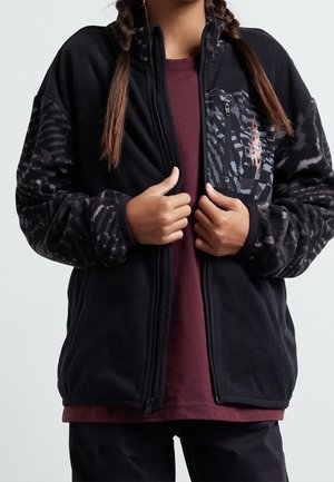 Sort fleecejakke med mønstrede ærmer, fuld lynlås og en lille lomme med et geometrisk design i mørke toner.
