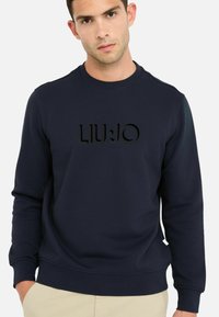 Dunkelblaues Sweatshirt aus Baumwollmischung mit Rundhalsausschnitt und gerippten Bündchen, mit einem erhabenen schwarzen Logo "LIU.JO" auf der Vorderseite.