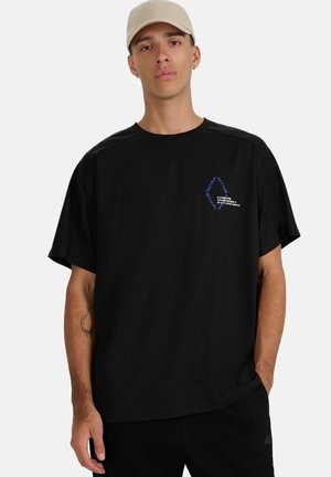 Czarny t-shirt z krótkim rękawem o luźnym kroju. Na przedzie znajduje się niebieski tekst graficzny. Wykonany z miękkiego materiału o minimalnej fakturze.