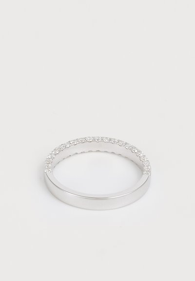 Inel din argint cu o suprafață netedă, împodobit cu mici cristale transparente pe marginea superioară. Design minimalist și elegant.