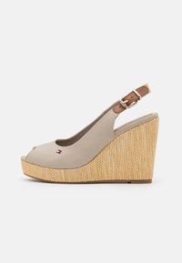 Sandali a zeppa beige con punta aperta e retro slanciato. Realizzati in tessuto liscio e materiale tessuto testurizzato, con un accento in fibbia marrone.