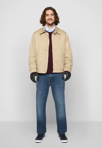 Bežna lahka jakna, maroon pulover, modra karirana srajca, modri džins, črne rokavice, črne superge. Ravna krojna, sproščen dizajn.