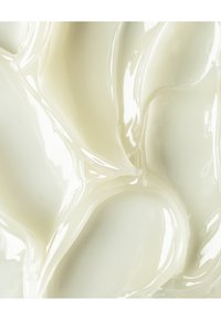 Substance crémeuse et brillante avec une texture lisse, variant dans des nuances de blanc cassé et de beige, présentant des courbes douces et fluides ainsi que des ondulations.