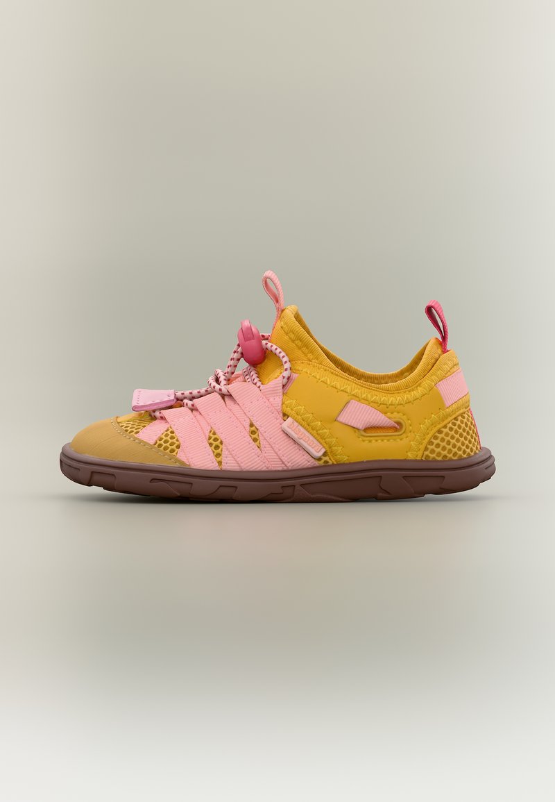 Baskets légères jaunes et roses avec panneaux en mesh, lacets à bride ajustable, et semelle texturée marron, présentées sur un fond neutre.