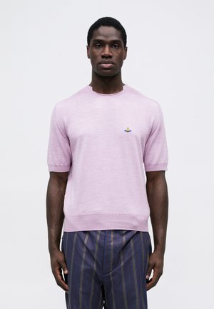 Lichtroze korte mouwen trui met een ronde hals en geribbelde zoom, voorzien van een klein geborduurd ontwerp. Glad textuur. Gecombineerd met gestreepte broek.