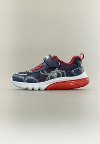 Παιδικό αθλητικό παπούτσι σε ναυτικό μπλε και κόκκινο με λευκή σόλα, σχέδιο ιστού αράχνης, λουράκι με βέλκρο και θηλιά στην πλάτη, σε ουδέτερο φόντο.