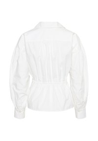 Camicia in cotone bianco con colletto strutturato, maniche a palloncino e vita elastica. Texture liscia con silhouette aderente.