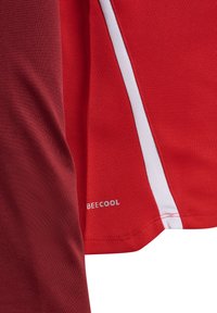 Rotes Sporttrikot mit Mesh-Textur, weißen Akzenten und dem aufgedruckten "BECOOL"-Logo auf der unteren Seite. Design mit Dreiviertelärmel.