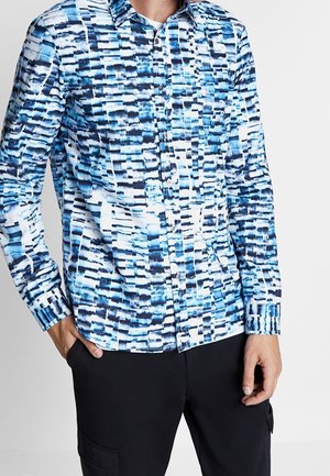 Camicia button-up con un motivo astratto blu e bianco, maniche lunghe, colletto classico e design aderente. Il materiale sembra leggero.