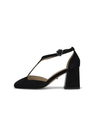 Zapato de tacón para mujer en ante negro con tacón bloque, diseño con tira en forma de T, y hebilla decorativa con cuentas en la correa del tobillo, mostrado en perfil lateral.