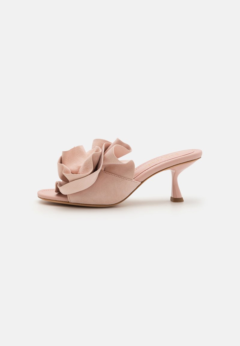 Sandalele cu toc din suede roz au o mare floare accent la partea din față, un design cu vârf deschis și un toc subțire, ușor curbat.
