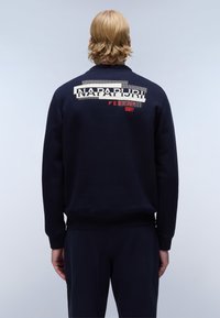 Marine sweatshirt met een gedurfde bedrukte logo op de achterkant, geribbelde manchetten en zoom. Gemaakt van zachte stof met een relaxte pasvorm.