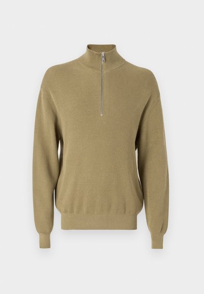 Strickpullover in olivgrün mit hohem Kragen und kurzem Reißverschluss vorne. Rippstruktur und lange Ärmel, lockere Passform mit schmal zulaufendem Saum.