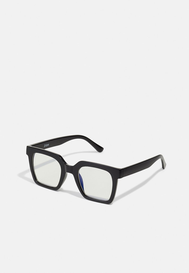 Óculos de sol quadrados pretos com acabamento mate, apresentando lentes transparentes e um leve tom azul de um lado. Design robusto e angular.