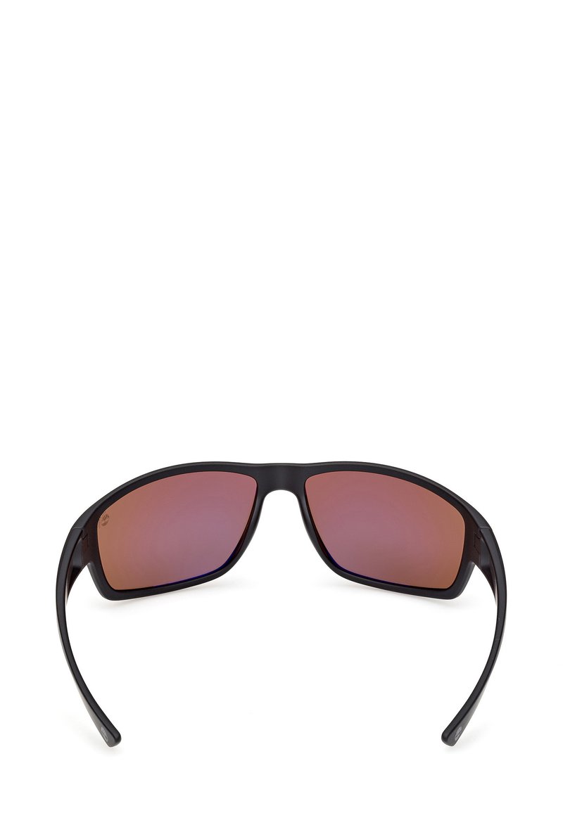 Lunettes de soleil avec une monture noire mate et des verres dégradés teintés de rose. Forme incurvée avec des branches élégantes, affichant un design moderne et un logo discret.