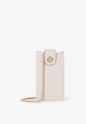 Custodia per telefono in pelle color crema con chiusura in oro e tracolla a catena abbinata in oro, in piedi su una superficie bianca.