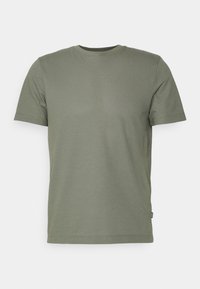 Krátké tričko olivově zelené barvy ze strukturované látky s kulatým výstřihem a detailním bočním štítkem. Jednoduchý, neformální design.