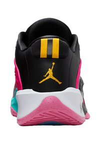 Scarpa sportiva nera e rosa con tomaia strutturata, dettagli gialli e suola trasparente color teal. Caratterizzata da un logo distintivo sul retro.