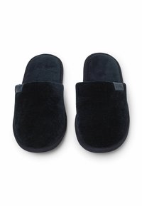 Schwarze Corduroy-Hausschuhe mit einem plüschigen Obermaterial und einem weichen Innenfutter. Sie verfügen über eine runde Spitze und eine dicke, strukturierte Sohle für zusätzlichen Komfort.