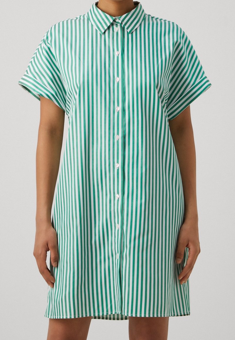 Kortærmet kjole med grønne og hvide striber, knappet foran og med klassisk krave, lavet af letvægtsstof.