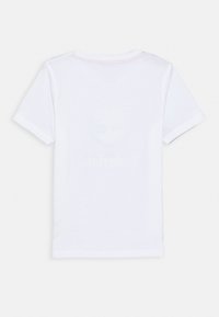 Camiseta blanca de manga corta y cuello redondo mostrada desde la espalda sobre un fondo blanco.