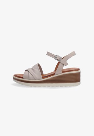 Beige læder wedge sandal med en knyttet frontdesign, justerbar ankelrem og en tekstureret mellemsål. Hvid ydersål med godt greb.
