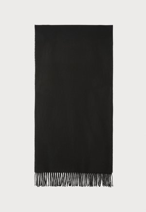 Svart strikket skjerf med frynsete kanter, myk tekstur, rektangulær form og minimalistisk design. Har en liten logo i hjørnet.