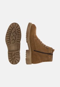 Bruna mockaskinnsankelkängor med sidodragkedja, gummisula med djupa mönster och snörningsdesign för en säker passform.