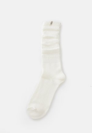 Calze bianche lavorate a maglia con un risvolto a coste arricciato, caratterizzate da un'etichetta con logo sul lato e una texture liscia su tutto il corpo.
