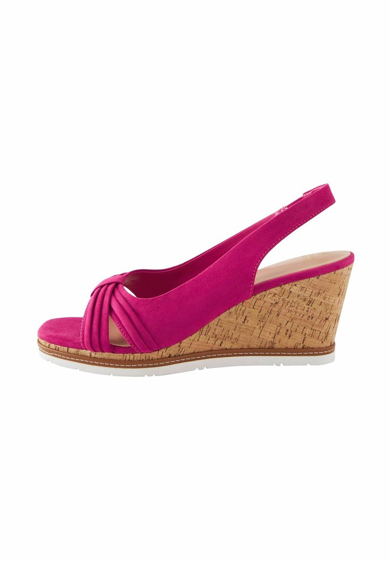 Sandale compensée fuchsia avec un bout rond, un design à l'avant noué, une texture en daim et un talon enveloppé de liège. Bride ajustable à l'arrière.