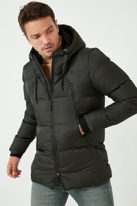 Giacca a vento nera con cappuccio, dotata di zip a due vie, polsini elasticizzati e due tasche anteriori con zip. Materiale liscio e imbottito.