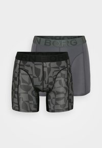 Δύο ζευγάρια ανδρικών μποξερ σλιπ: ένα γκρι και ένα σε σχέδιο μαύρο με αφηρημένα σχήματα. Και τα δύο διαθέτουν μαύρη ελαστική ζώνη με κείμενο.