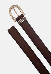 Bruine leren riem met een goudkleurige gesp, rechthoekige sluiting gegraveerd met "MICHAEL KORS," met meerdere bevestigingsgaten.