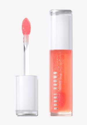 Gloss à lèvres corail brillant avec paillettes dans un tube rectangulaire transparent et un capuchon blanc, applicateur avec embout souple incliné recouvert de produit.