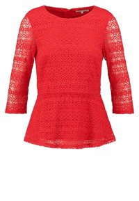Haut en dentelle rouge avec des manches trois-quarts, col rond, silhouette peplum, présentant un motif en zigzag et des détails texturés.