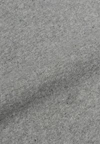Tessuto di cotone grigio chiaro con una superficie morbida e texture. Presenta un sottile motivo melange con piccole macchie di grigio scuro sparse.