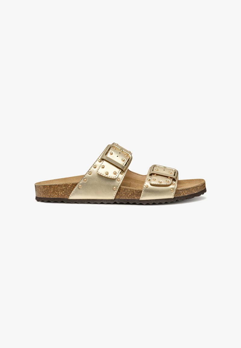 Sandales à glisser en cuir doré avec deux larges brides, chacune dotée de boucles carrées. Semelle extérieure texturée avec un pied en liège, bord en zigzag.