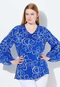 Blusa blu con motivo floreale bianco, design a V, con maniche a campana. Realizzata in un tessuto leggero con una texture liscia.