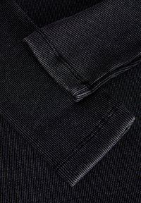 Zwarte ribstof met fijne verticale strepen, met een zachte textuur en omgevouwen randen, die verschillende tinten zwart en grijs toont.