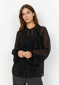 Black semi-transparent blouse with ruffled front, button closure, and bell sleeves. Features a collar and smooth fabric texture.