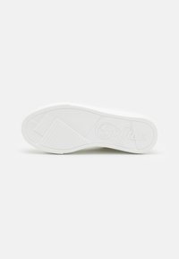 Bílá podrážka boty s texturovanými gripovými vzory a logem "Buffalo" vyraženým na spodní straně, vystavená na čistě bílém pozadí.