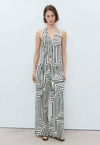 Black and white striped two-piece outfit featuring a sleeveless top with a button closure and wide-leg pants with a flowing design.