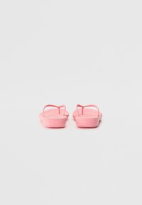 Roza natikače s ravnimi podplati in ozkimi trakovi. Narejene iz fleksibilnega materiala, z gladko teksturo in zaobljenimi robovi.