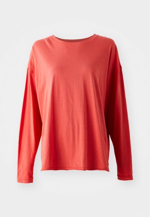 Langärmliges korallenrotes T-Shirt mit Rundhalsausschnitt, lockerer Passform und sichtbaren Nähten an Ärmeln und Saum, vor einem weißen Hintergrund präsentiert.