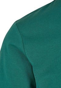 Zöld crew-neck póló rövid ujjakkal, bordázott textúrával és zökkenőmentes vállvonal kialakítással. Puha pamut anyag a kényelem érdekében.