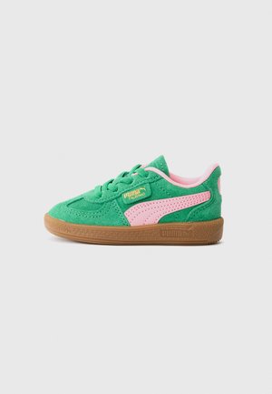 Baskets Puma Palermo en suède vert avec une rayure et un intérieur rose, semelle en caoutchouc marron et logo doré sur le côté et le talon, présentées en vue de côté.