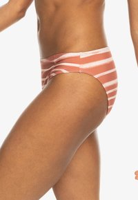 Bas de maillot de bain corail avec des rayures horizontales blanches, fabriqué en tissu lisse. Présente une coupe taille basse et une silhouette ajustée.